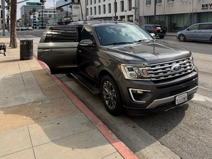 Luxury SUV waiting at the curb in Beverly Hills with the rear door open